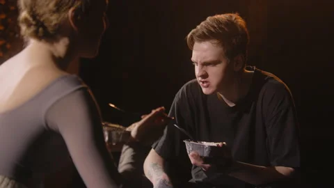 Tired ballet dancers sit on stage and ea... | Stock Video | Pond5