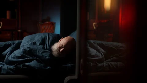 Tired bearded middle-aged man lies awake in bed, struggling with insomnia Stock Footage 342520855