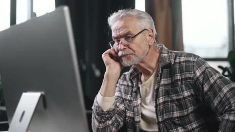 Tired boring gray haired senior man freelancer feeling annoyed at workplace Sad Stock Footage 253513587