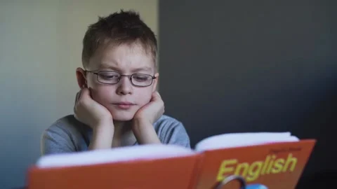 Tired boy with glasses does his homework Stock Footage 87379158