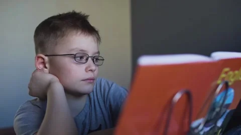Tired boy with glasses does his homework 스톡 동영상 87379189