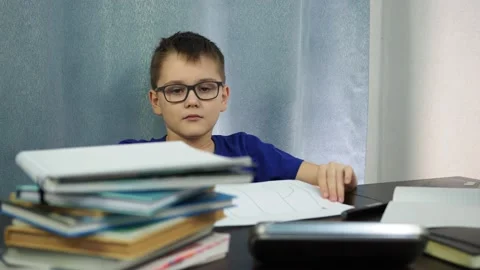 A tired boy sitting at a table shows a sign that says help. I'm tired of Stock Footage 145145228