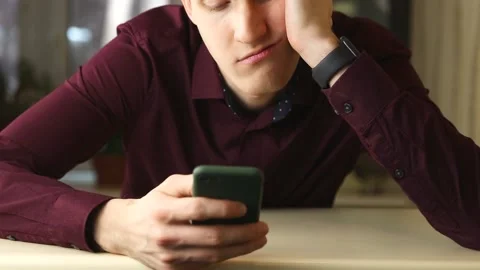Tired buisnessman using smartphone, surfing social media and want to sleep Stock Footage 148043091