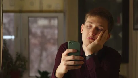 Tired buisnessman using smartphone, surfing social media and want to sleep Stock Footage 148043179