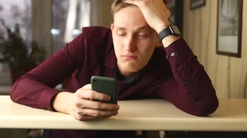 Tired buisnessman using smartphone, surfing social media and want to sleep Stock Footage 148043368