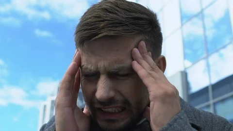 Tired business man having sharp pain attack outdoors, headache caused by stress Stock Footage 117223069