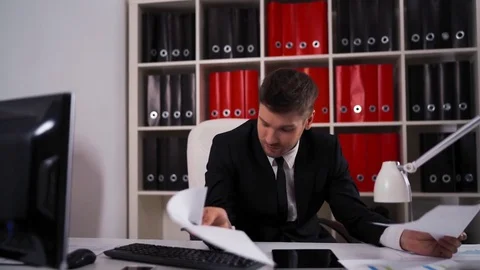 Tired businessman with documents falling asleep in office Video stock 75990705