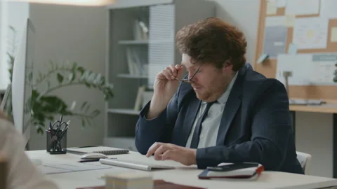 Tired Businessman Working on Computer and Rubbing His Eyes in Office Stock Footage 331557074