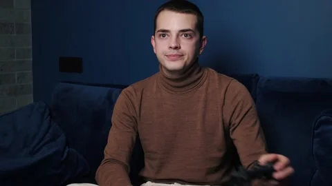 Tired caucasian man holding controller, playing games alone on sofa at home Stock Footage 144331345