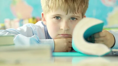  A tired child with book.  Stock Footage 78239633