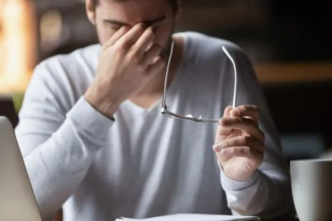 Tired of computer businessman taking off glasses feels eyestrain Stock Photos