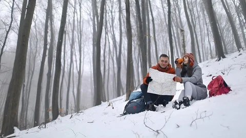 Tired Couple Reading The Map, Sitting in Forest 動画素材 103772533