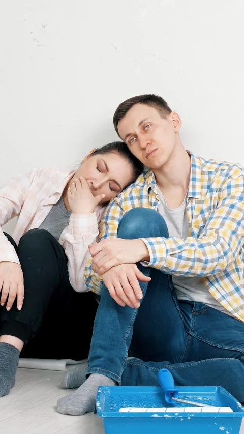 Tired couple resting on the floor during home renovation, exhausted man and Stock Footage 342910127