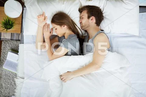 Tired couple sleeping under blanket Stock Photos
