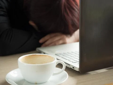 Tired creative editor sleeping on laptop at office Stock Photos