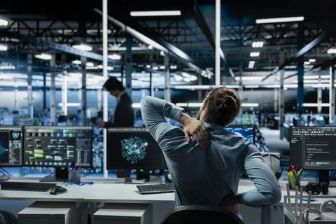 Tired data center software developer stretching to ease back tension Stock Photos