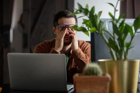 Tired developer working with laptop at home Foto stock