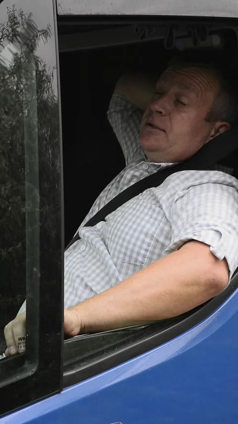 Tired driver rubbing eyes and resting in truck vertical Stock Footage 340078166
