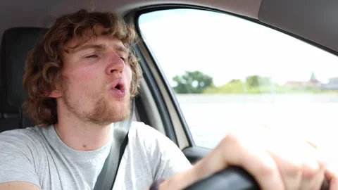 Tired driver yawns behind the wheel while driving through the city Video stock 343720325