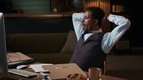 Tired Editor Eating Biscuits Working on Computer at Desk in Home Office Stock Footage 306924186
