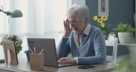 Tired elderly woman using her laptop and having a headache Stock Footage 151213009