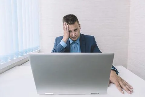 A tired employee at work in front of a computer monitor. Thoughtful busines.. Foto stock