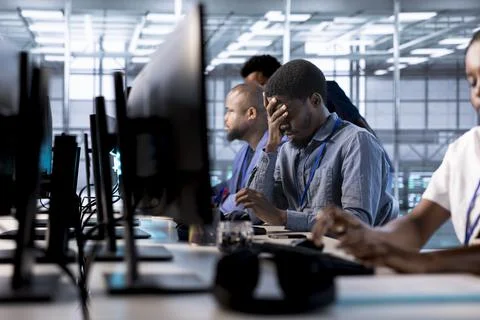 Tired engineer feeling headache working in ensure data center 写真素材