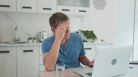 Tired exhausted man freelancer working at home on laptop, overworked, needs rest Video stock 250534993