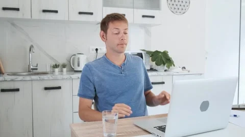 Tired exhausted man freelancer working at home on laptop, overworked, needs rest Stock Footage 252117613