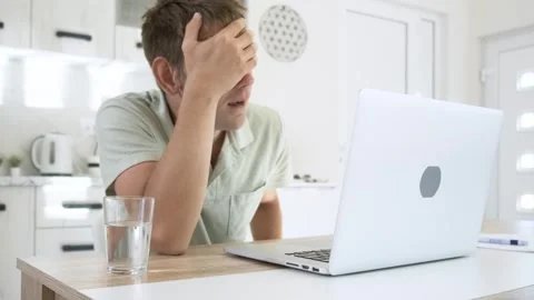 Tired exhausted man freelancer working at home on laptop, overworked, needs rest Stock Footage 260843138