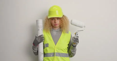 Tired exhausted responsible female builder holds paining roller and paper Stock-Footage 156225835