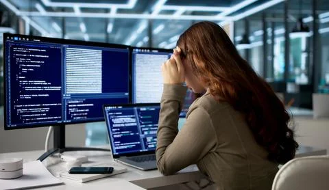 Tired Female Web Developer Codes At Her Desk Feeling Frustrated And Unhappy. Foto stock