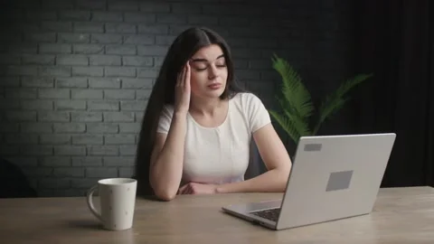 Tired freelancer typing on computer keyboard and rubbing forehead. A young Stock Footage 233062637