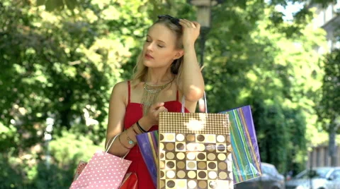 Tired girl standing with shopping bags and yawning all the time Stock Footage