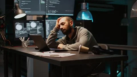 Tired IT engineer sleeping and trying to work on programming Stock Photos