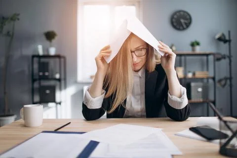 Tired lady stressing while working with paper documents Foto stock