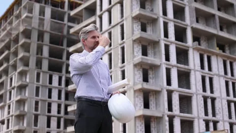 Tired male engineer taking off safety helmet touching forehead while working Stock Footage 340068082