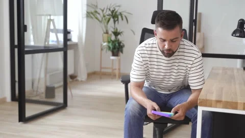 Tired male worker playing with push pop fidget toy in the office Stock Footage 233757970