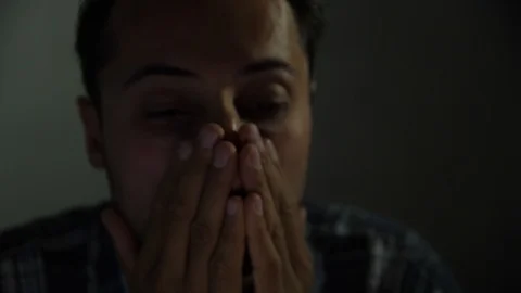 Tired man in the evening working at the computer and rubs his face Video stock 96875734