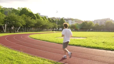 Tired man exercising running along a running track Stock Footage 299896582