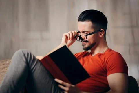 Tired Man with Eye Problems Reading a Book Stock Photos