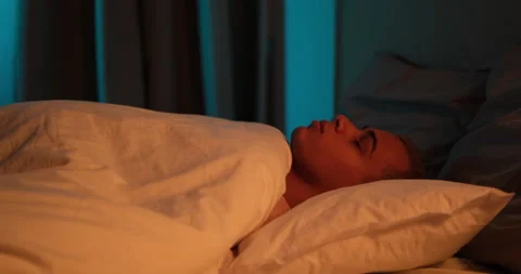 Tired man falling asleep on bed 動画素材 145290585