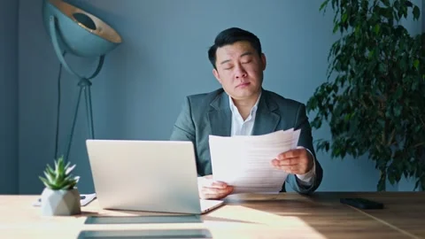 Tired man falling asleep while reading documents during work process in cabinet 库存影片 275807029