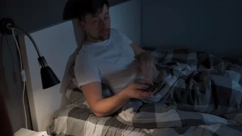 Tired man holds a TV remote control in Stock Video Pond5