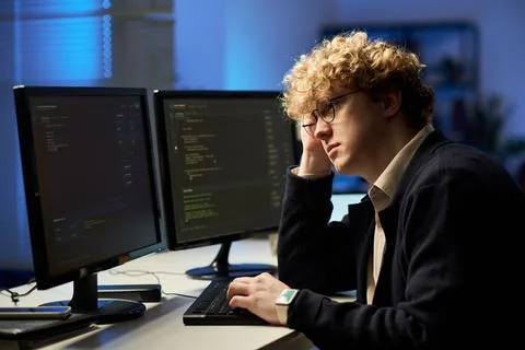 Tired Man Programming Software on Multiple Computer Monitors Stock Photos