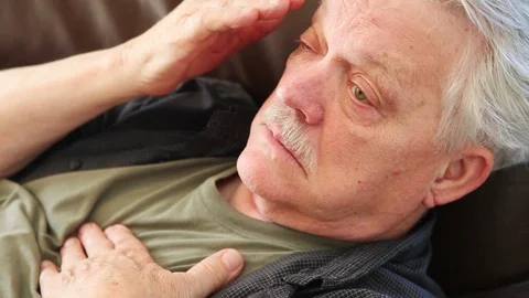 Tired man rubs eyes while lying down Stock Footage 88962218
