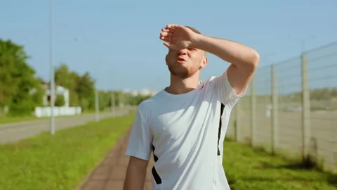 Tired man runner stopped checks mail use phone running outdoors at sunlight on Stock Footage 140365888