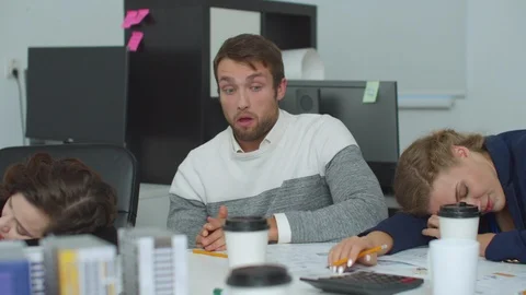 Tired man sit a table and clap his face to continue to work Stock Footage 121814558