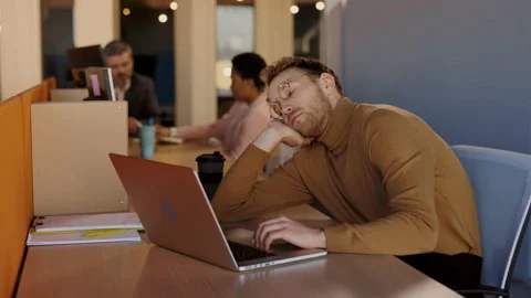 Tired man sleeping at his workplace. Sleepy and boring businessman trying to 動画素材 197294063