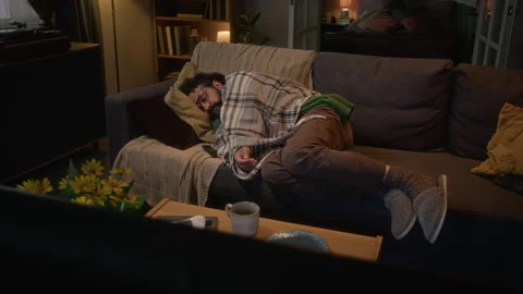 Tired Man Sleeping on Sofa in Front of Television at Night Stock Footage 341676850